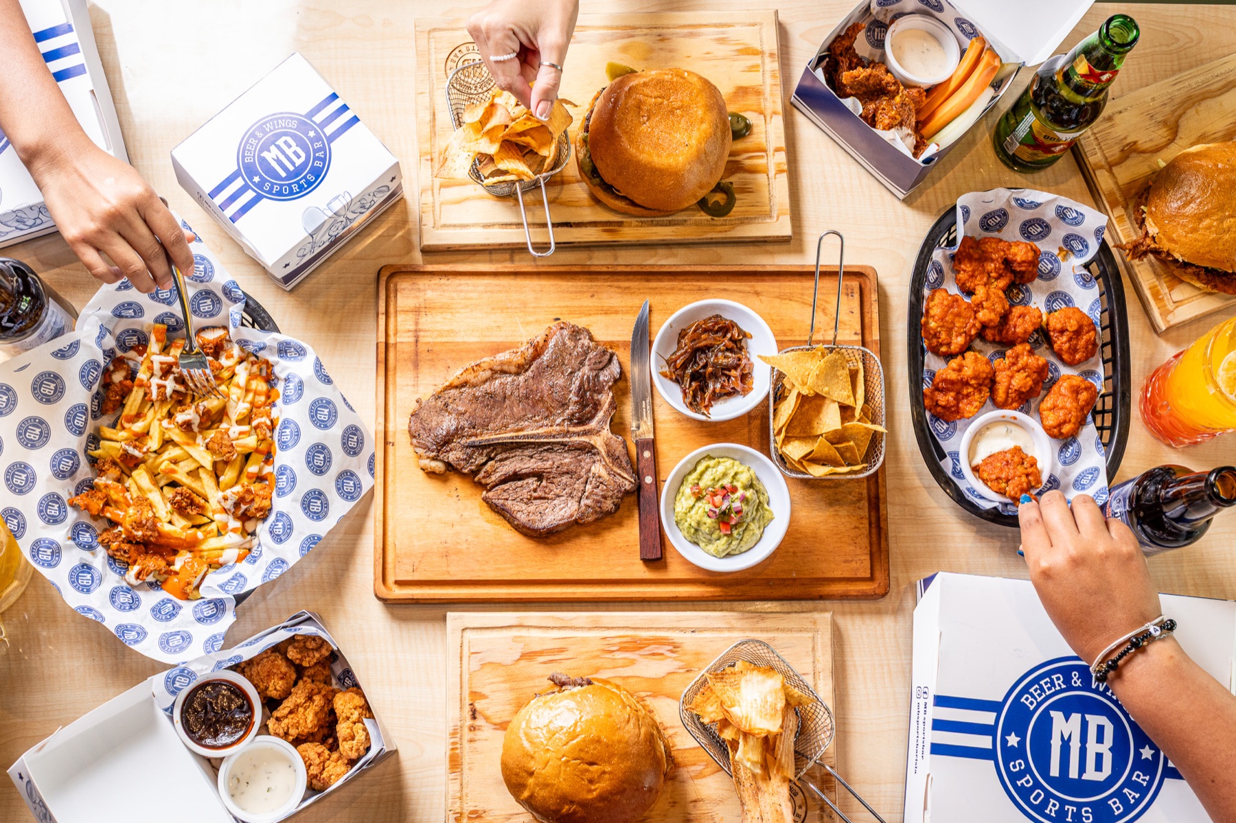 Mesa abundante con hamburguesas y alitas