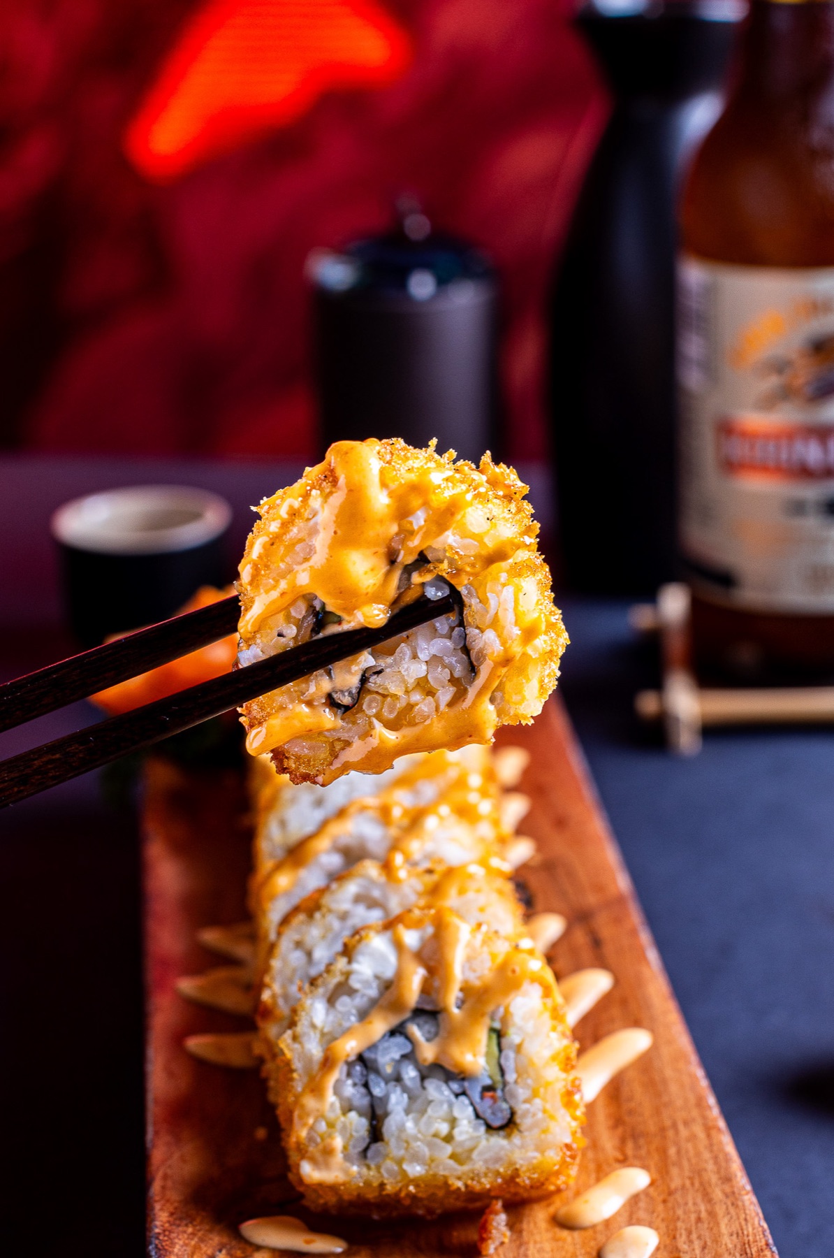 Pieza de sushi sostenida con palillos