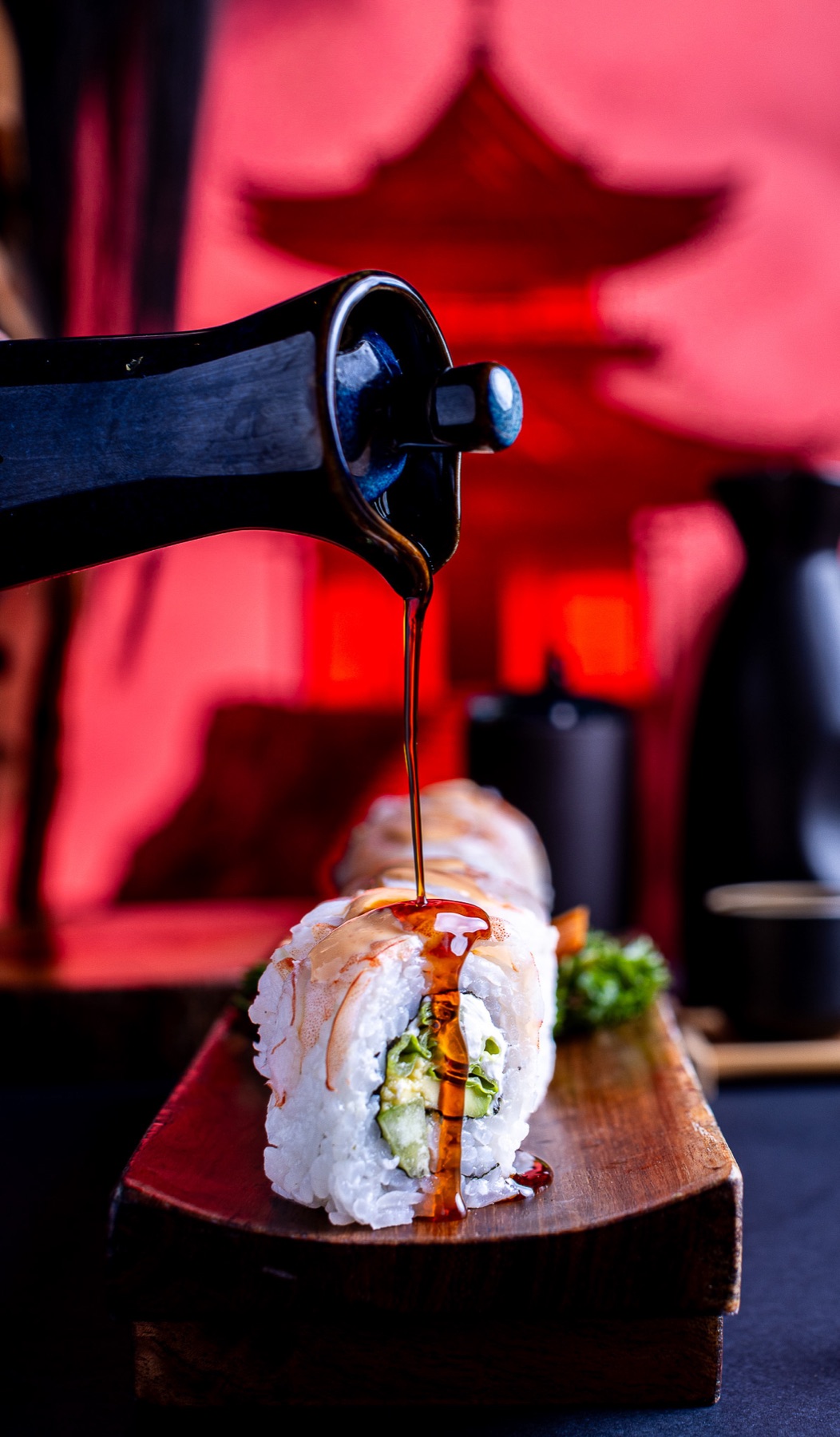 Salsa cayendo sobre un rollo de sushi
