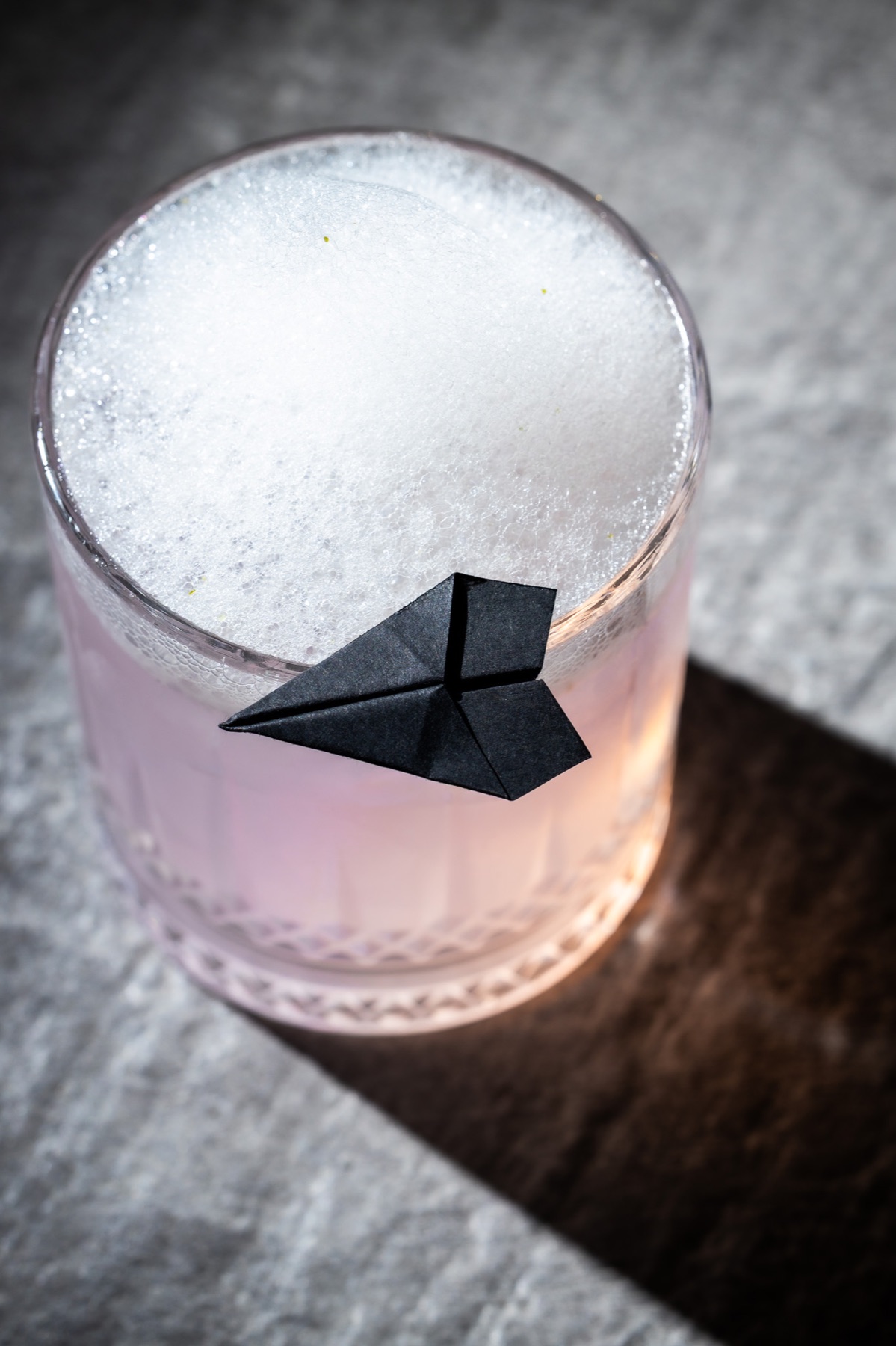Coctel rosa con espuma y detalle de origami