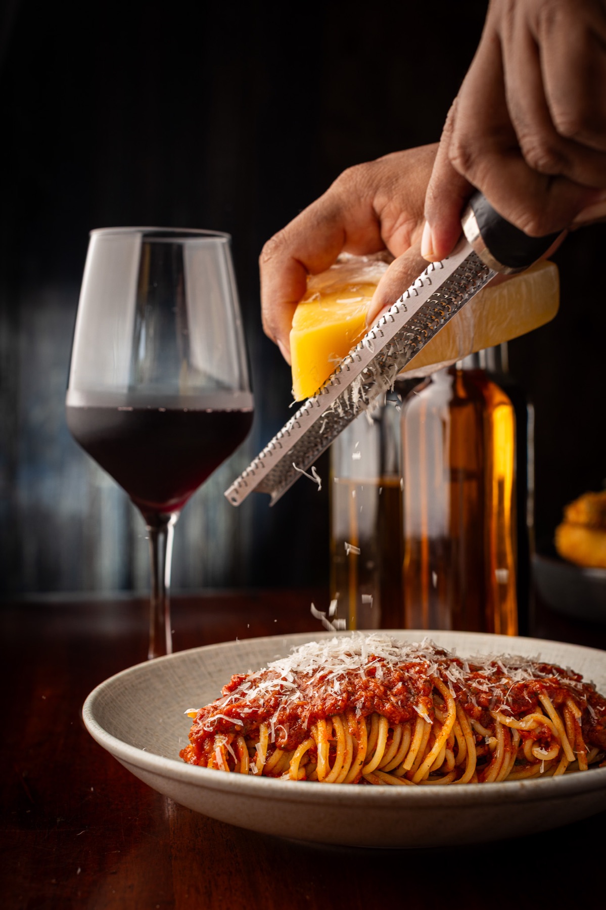 Queso rallado sobre pasta y vino