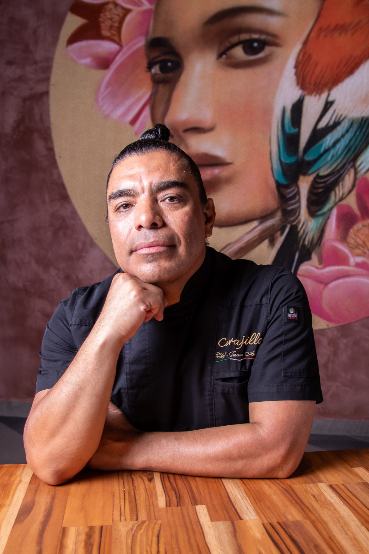 Retrato de chef frente a un mural contemporáneo