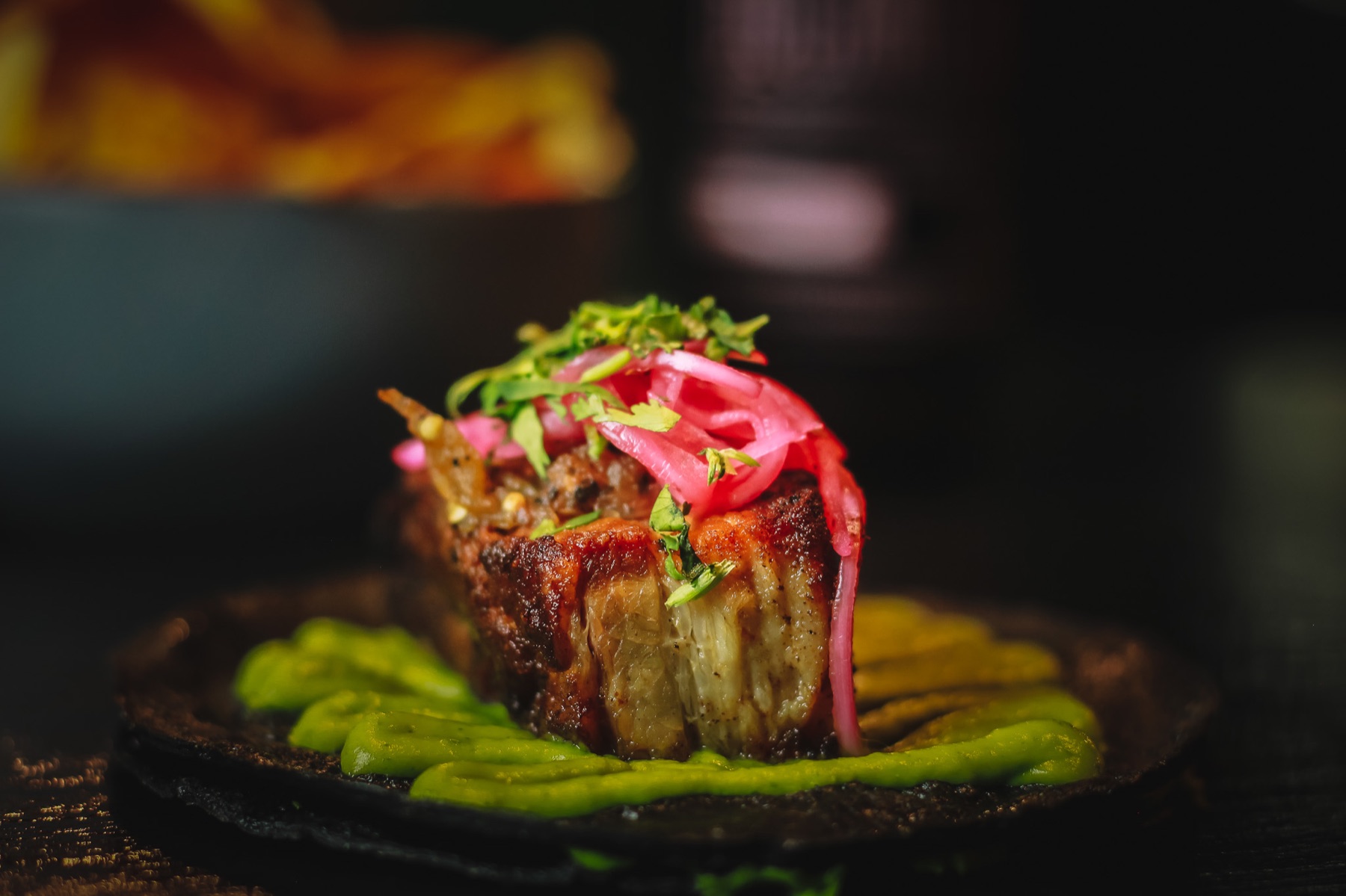 Platillo de carne con cebolla encurtida y puré verde
