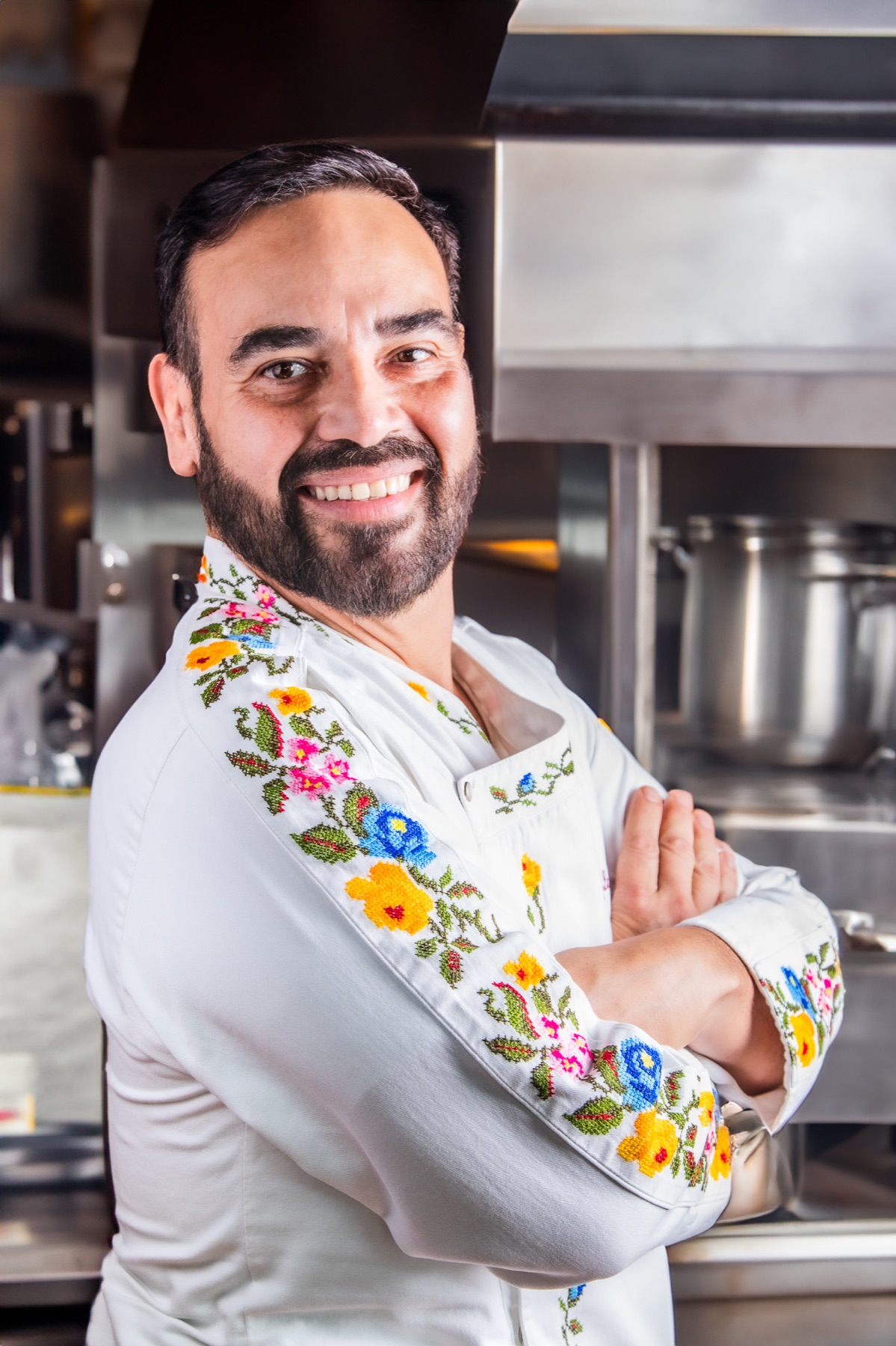 Retrato de chef con filipina bordada en una cocina profesional