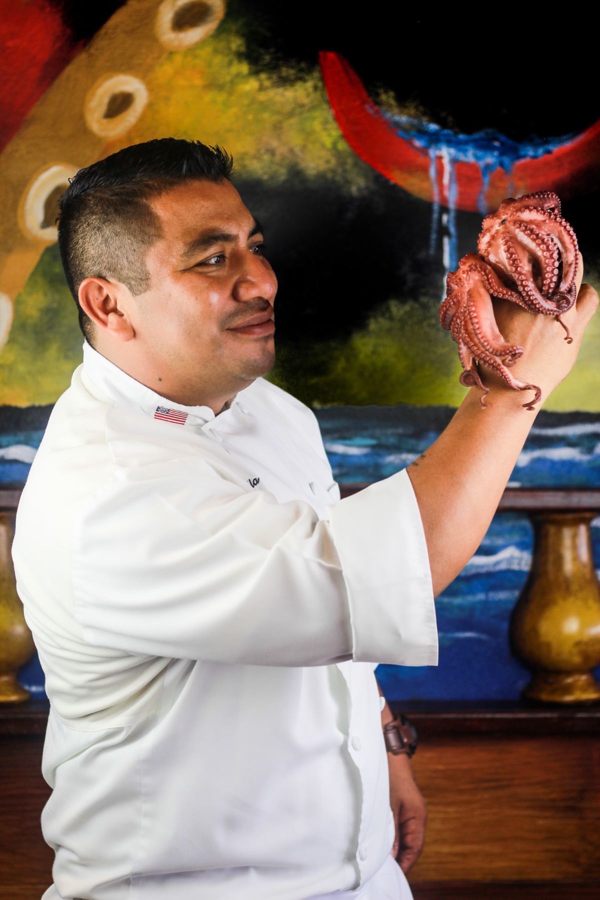 Chef presentando un pulpo en su cocina