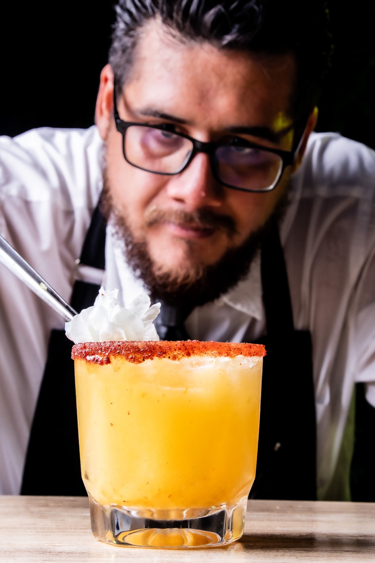 Bartender detrás de un coctel amarillo recién preparado