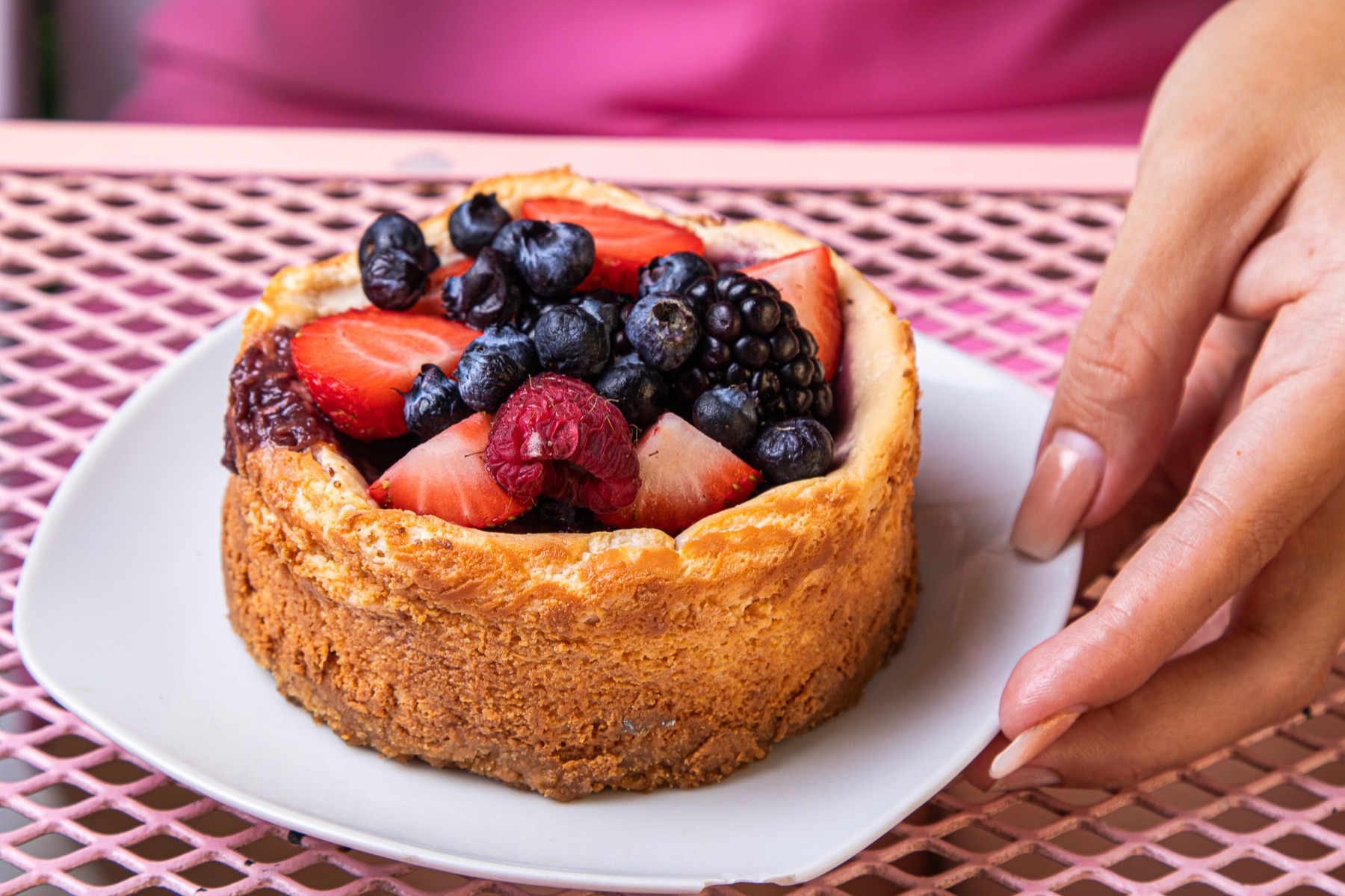 Pastel de frutos rojos sobre una mesa rosa